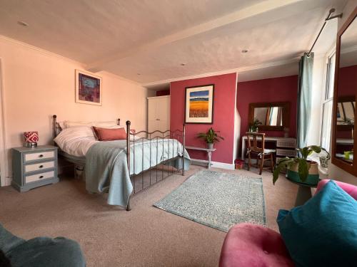 a bedroom with a bed and a desk in it at Flemish House in Beccles