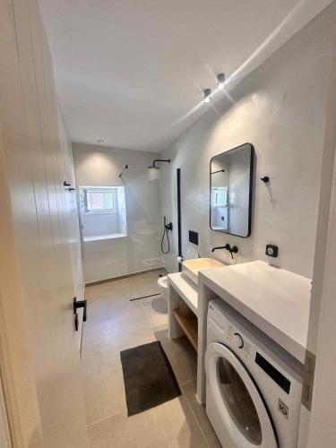 a bathroom with a washing machine and a sink at Little Kamara Ios in Ios Chora