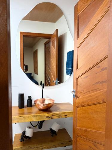 a bathroom with a wooden sink and a mirror at Recanto Tavares in Linhares