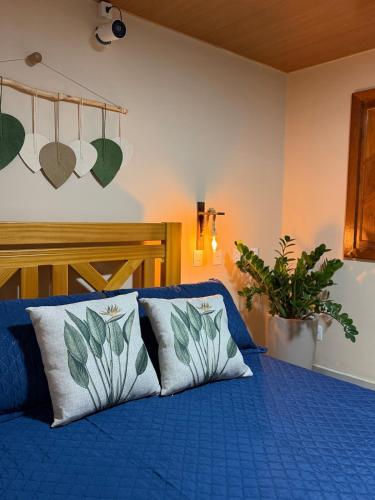 a bedroom with a blue bed with two pillows at Recanto Tavares in Linhares