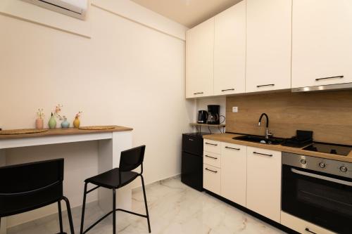 a kitchen with white cabinets and black appliances at Almond Jacuzzi Suites - Private Indoor Jacuzzi - Self Check-In - Free & Easy Street Parking in Thessaloniki