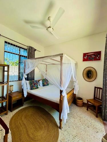 a bedroom with a bed with a canopy at Nilio Explorer & Lodge in Mfumbwi