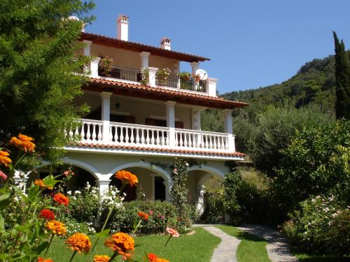 a large house with flowers in front of it at Alexandros Apartments & Studios in Agios Gordios