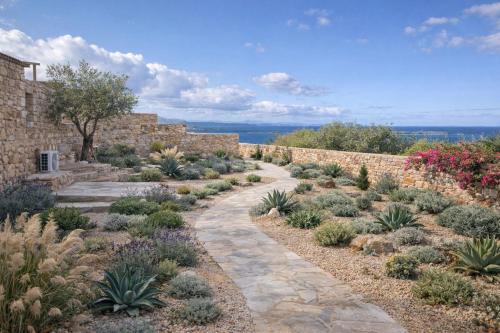 ein Garten mit Pflanzen und einer Ziegelmauer in der Unterkunft Mythic Paros , Adults Only in Agia Irini Paros