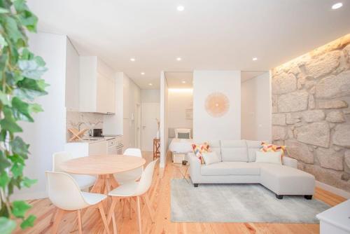 a living room with a white couch and a table at Liiiving in Porto - Aliados Stone Apartment in Porto