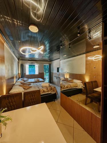a room with two beds and a table and chairs at Espaços Cardoso, HORIZONTE- amplitude e respiro in Igrejinha