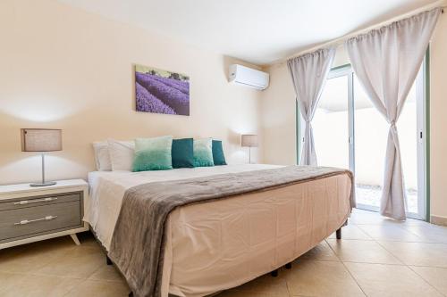a bedroom with a large bed and a large window at Palma Divine Condo-2BR-2BTH-Pool in Noord