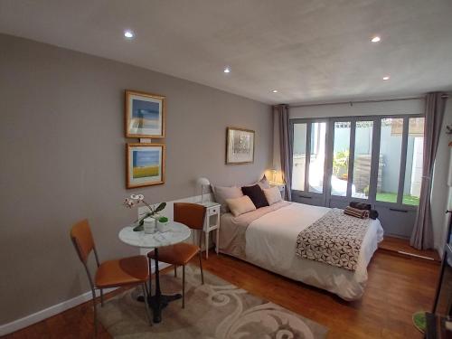 a bedroom with a bed and a table and a window at Villa Angelus in Nice