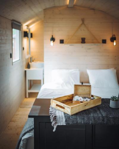 a bedroom with a bed with a tray on a table at Camping Papillon Kinrooi - Pipowagen 2p in Kinrooi