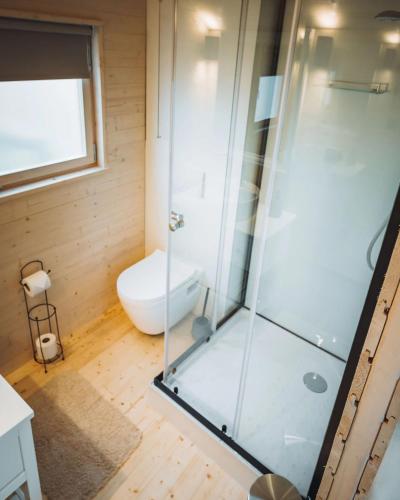 a glass shower in a bathroom with a toilet at Camping Papillon Kinrooi - Pipowagen 2p in Kinrooi