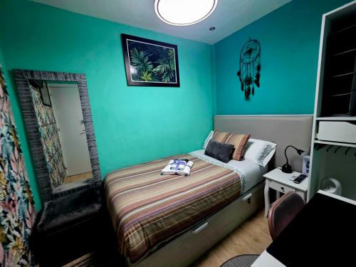 a bedroom with a bed and a green wall at Casa Atocha 1913 Apartamento Histórico con Encanto in Madrid