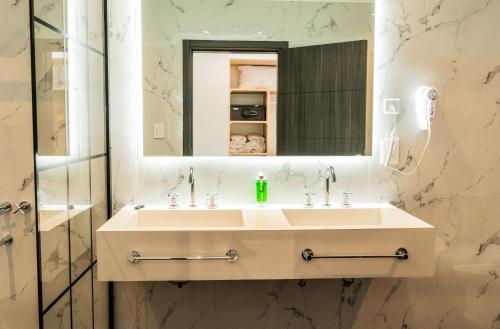a bathroom with a sink and a mirror at Palmas de la Laguna by Posada Suiza in San Miguel del Monte