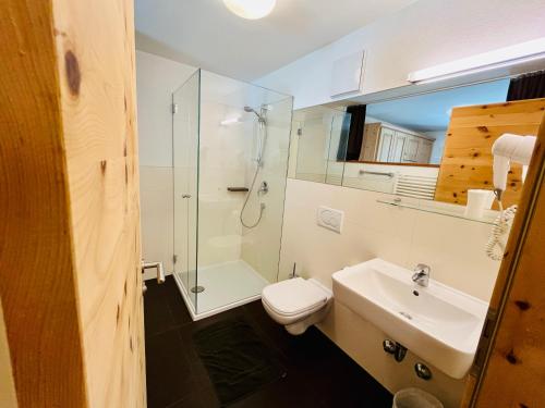 a bathroom with a toilet and a sink and a shower at Hotel Hofer in San Valentino alla Muta
