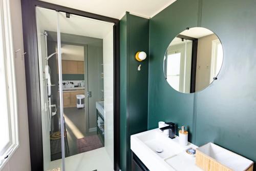 a bathroom with a green wall and a mirror at Camping Papillon Kinrooi - Vakantiehuis Familie 6P in Kinrooi