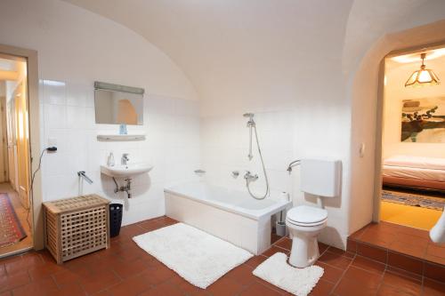 a bathroom with a tub and a toilet and a sink at Ferienwohnung Ottmanach Josefhof in Pischeldorf
