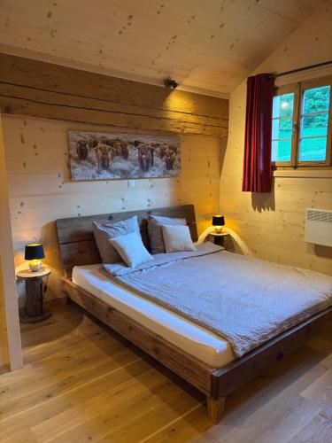 a bedroom with a large bed in a wooden room at Au Pré des Chevaux in Chateau-d'Oex