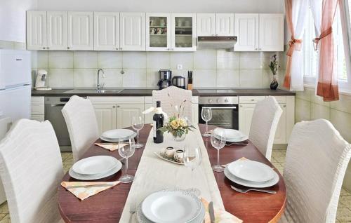 a kitchen with a table with white plates and wine glasses at Apartment Put Mocila Vi in Otok Mrduja