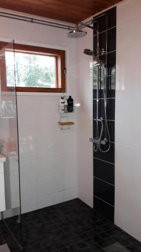 a bathroom with a shower with black and white tiles at Halkolanniemi in Muurame