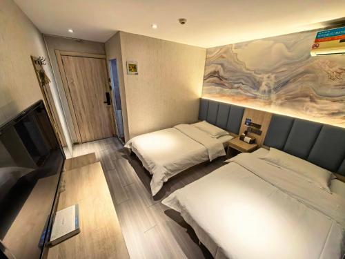 a room with two beds and a painting on the wall at 木子酒店 in Nanjing