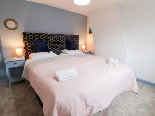 a bedroom with a large white bed with two pillows at Lilly Cottage in Woodbridge
