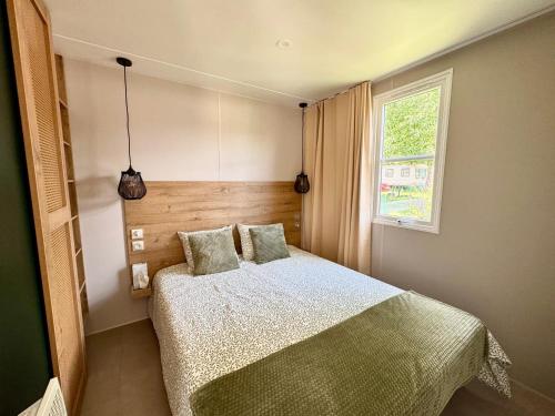 a bedroom with a bed and a window at Camping Papillon Bouillon - Vakantiehuis Relax 4P in Bouillon