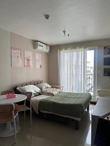 a bedroom with a bed and a table and a window at Saekyung 301-1603 in Concepcion