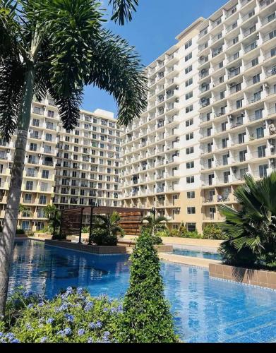 a large apartment building with a swimming pool and palm trees at Saekyung 301-1603 in Concepcion
