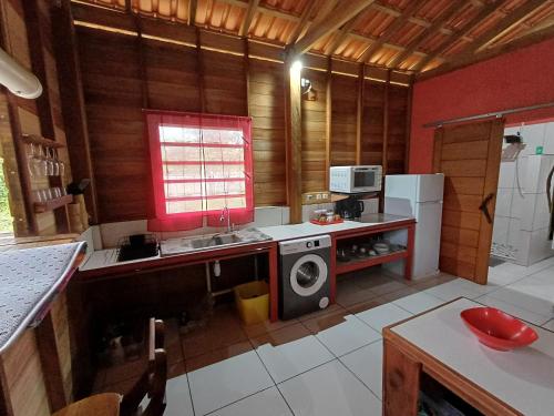 eine Küche mit Spüle und Waschmaschine in der Unterkunft Casa vermelho in Saint-Georges