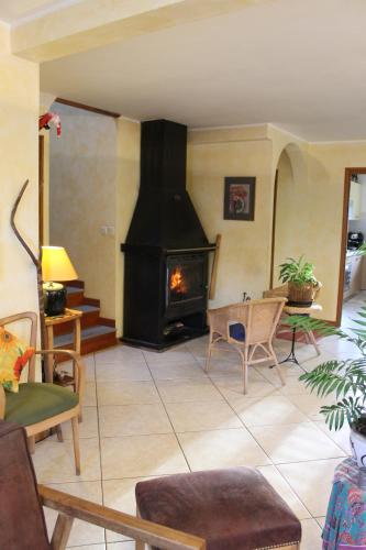 a living room with a fireplace and a table and chairs at B&B La Borella Casa Conti in Vallouise