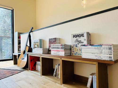 a room with a table with books and a guitar at HIKE Hayama愛犬と過ごす葉山のマウンテンビュー大人定員4名 in Hayama