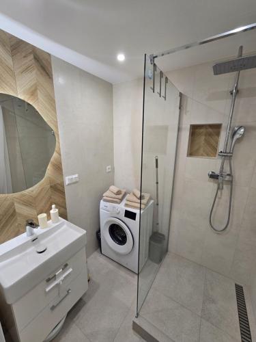 a bathroom with a washing machine and a shower at Apartmány Baťovany in Partizánske
