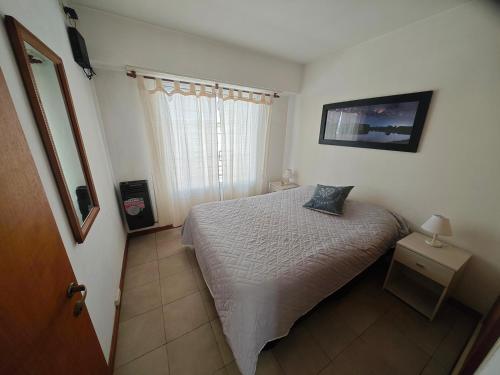 a small bedroom with a bed and a window at Depto AC Olavarria in Olavarría