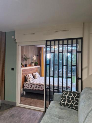 a bedroom with a bed and a sliding glass door at L'écrin des hauts in Saint-Denis