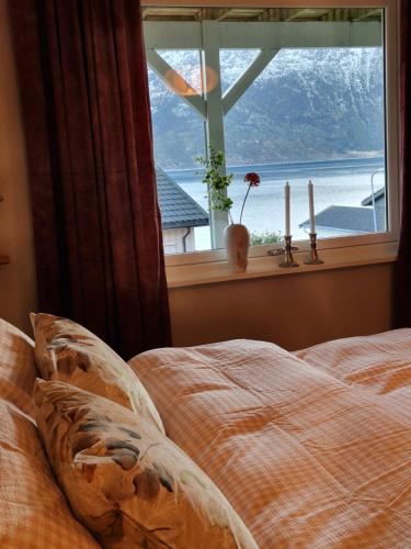a bed in front of a window with a view at Hessahuset in Ålesund