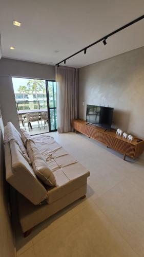 a bedroom with a bed and a flat screen tv at Ipioca Beach Life Maceió beira mar in Maceió
