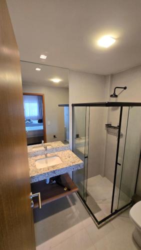 a bathroom with a sink and a shower at Ipioca Beach Life Maceió beira mar in Maceió