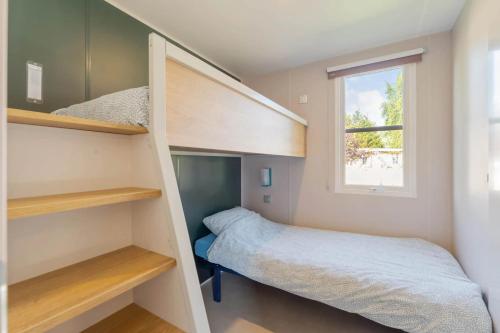 a small bedroom with bunk beds and a bed at Camping Papillon Kinrooi - Vakantiehuis Premium 4P in Kinrooi