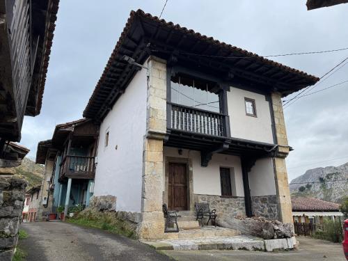 a small white building with a balcony on a street at El Refugio del Busgosu in Pen