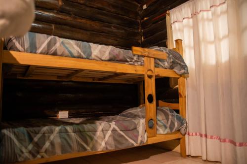 a bunk bed in a room next to a curtain at Cabañas San Francisco in Potrerillos