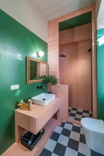 a bathroom with a sink and a toilet at The Urban Parrot Maisonette in Ermoupoli