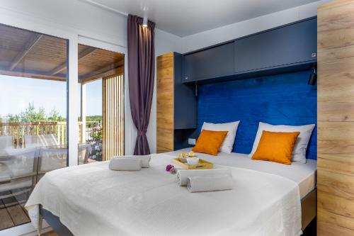 a bedroom with a large white bed with orange pillows at Camp Panorama Plus with Pool in Drage