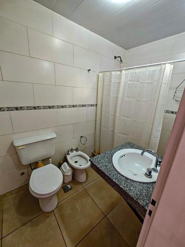 a bathroom with a toilet and a sink at Dpto URQUIZA Olavarría in Olavarría