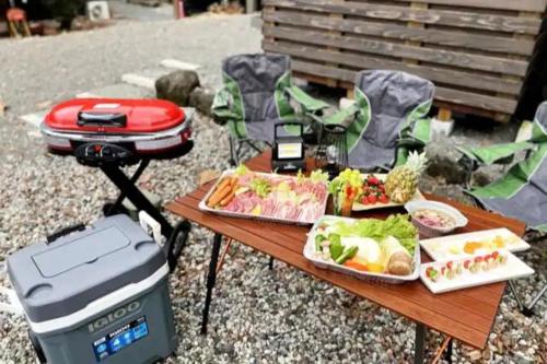 a picnic table with food on it and a grill at Fuji Time traveler 新館 in Fujikawaguchiko