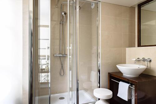 a bathroom with a shower and a toilet and a sink at Holiday Inn Paris Palais de l'Elysée by IHG in Paris