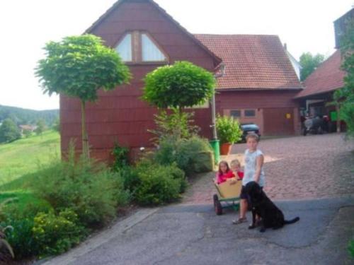 a woman with two children and a dog on a wagon at Ferienhof Christmann in Mossautal