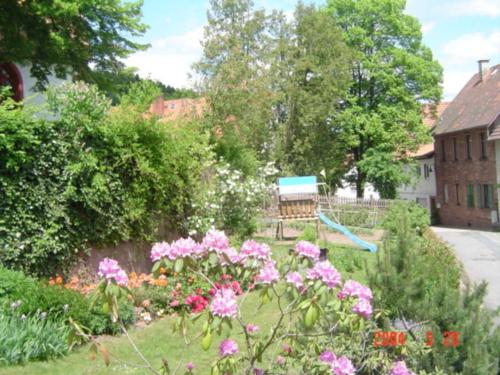 a garden with pink flowers and a bench at Ferienhof Christmann in Mossautal