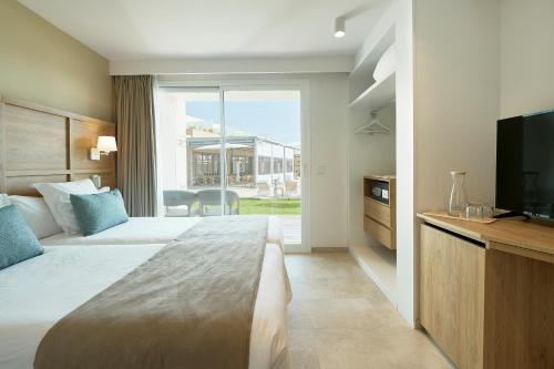 a hotel room with a large bed and a television at Iberostar Waves Cala Domingos All Inclusive in Calas de Mallorca