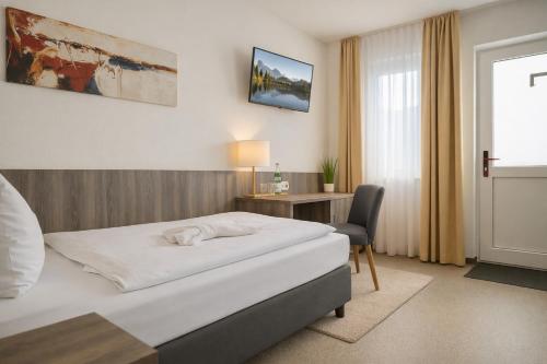 a hotel room with a bed and a desk at Sunny Hotel Regenstauf in Regenstauf