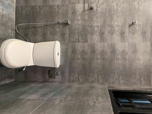 a bathroom with a white towel dispenser on the wall at Turtle Moon Lodge in Rekawa