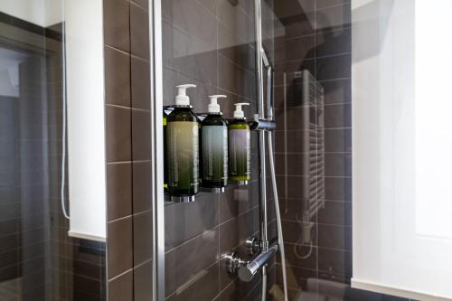 a bathroom with four bottles on a shower wall at D'Stay in Bari